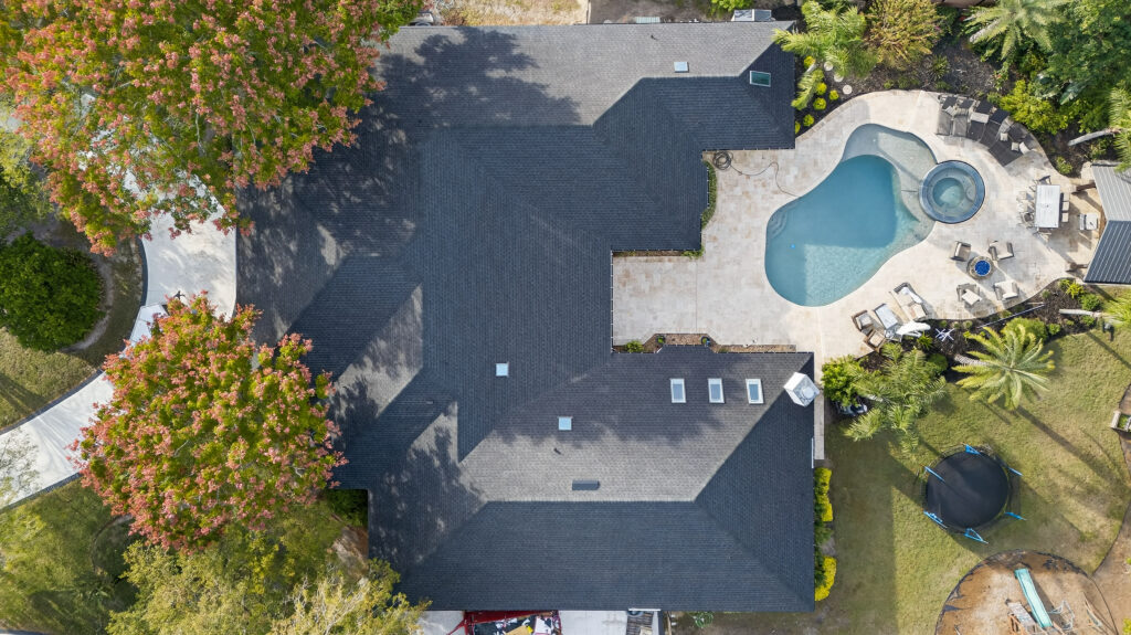 Aerial view of a Jacksonville Florida pool home showing a completed roof replacement using GAF shingles.